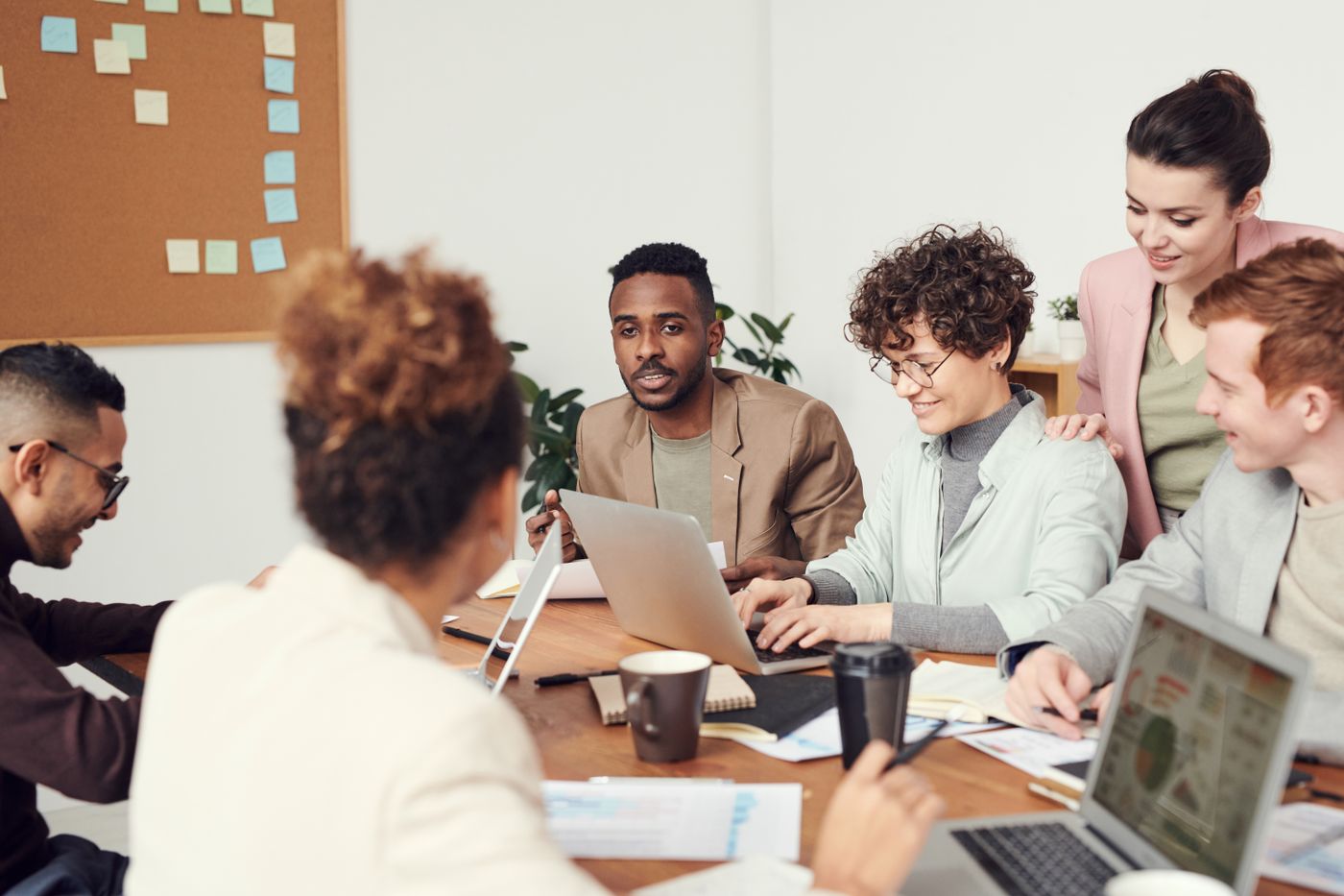 A business team collaborating around a laptop